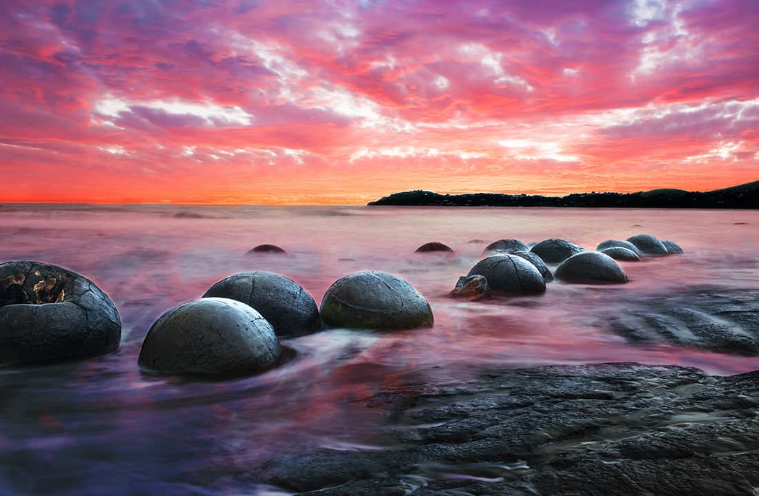 Moeraki Boulders on the Koekohe beach, Eastern coast of New Zealand. Sunset and long exposure