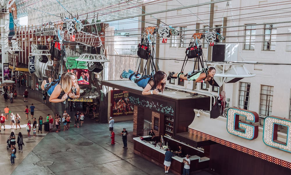 Zip line riders fly above Freemont Street