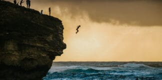 Cliff jumping at Shipwrecks beach in Kauai Hawaii