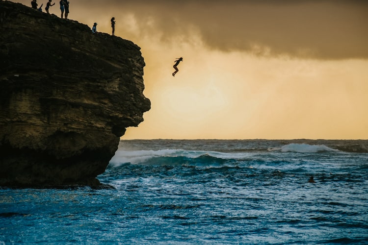 Cliff jumping at Shipwrecks beach in Kauai Hawaii