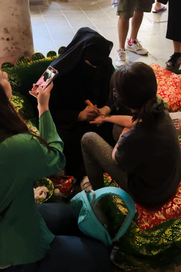 A girl getting a Henna Tattoo by a local in Doha, Qatar