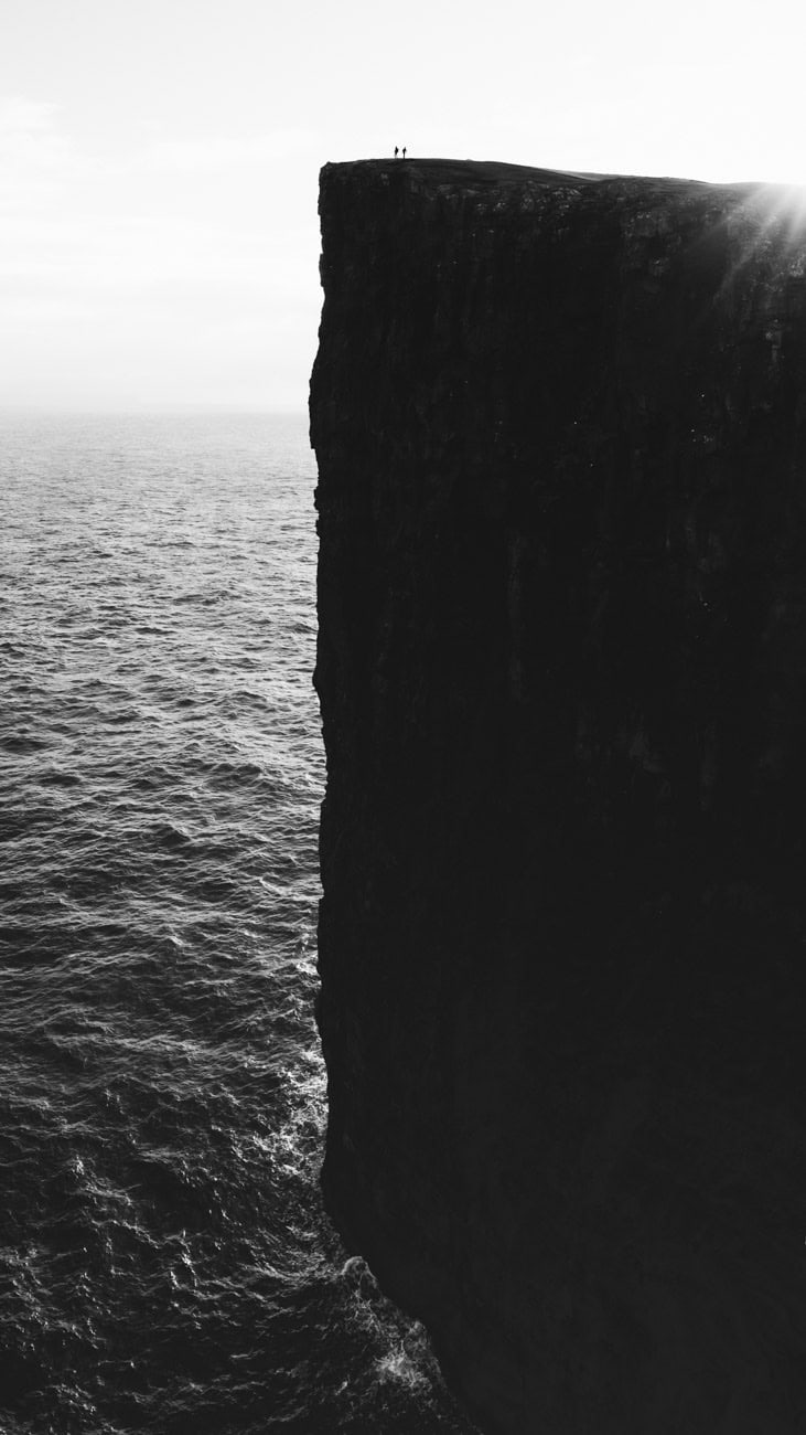 People standing on the edge of the Trælanípa sea cliffs during the Lake Sørvágsvatn hike in the Faroe Islands.