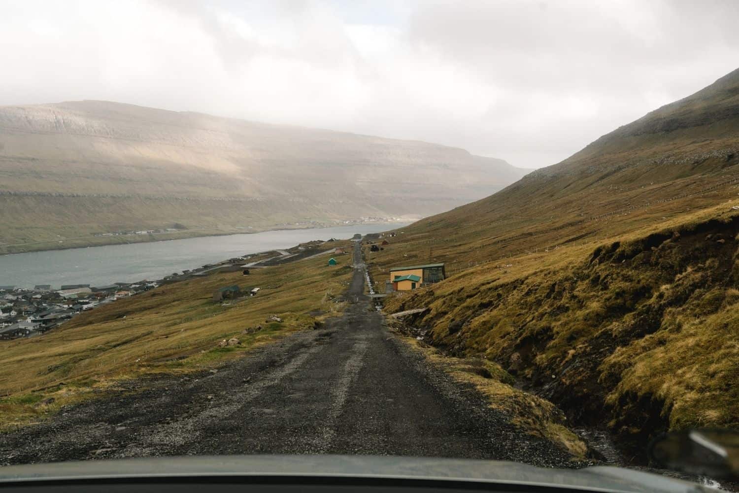 Narrow gravel road climbing above Klaksvík toward the upper parking area near Hálsur.
