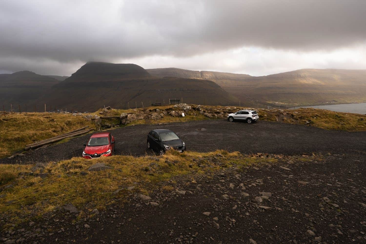 Upper parking lot for the Klakkur hike near Hálsur with mountains in the background.