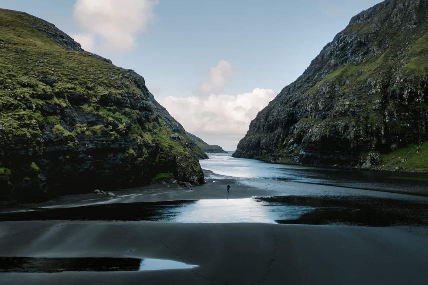 View along the Saksun Lagoon Walk with the black sand beach visible in the distance between the cliffs