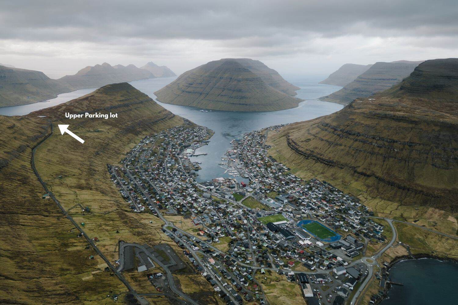 Klaksvík and surrounding mountains viewed from the Klakkur hike, with the upper parking lot marked on the hillside.